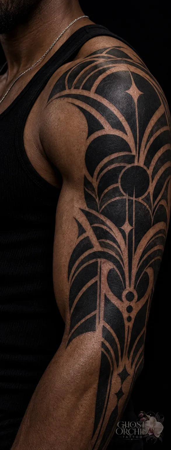 Blackwork half sleeve in solid black, built from arcing petal shapes and negative-space linework running from shoulder to elbow