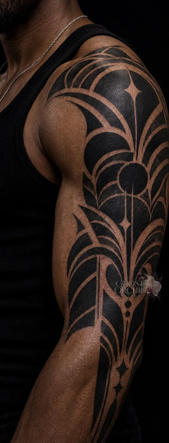 Blackwork half sleeve in solid black, built from arcing petal shapes and negative-space linework running from shoulder to elbow