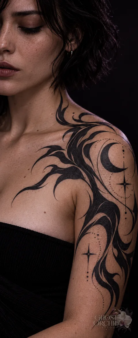 Blackwork shoulder piece: bold sweeping black forms curving from the chest over the shoulder, with a crescent moon and four-point star held in negative space
